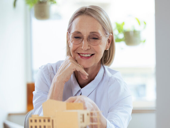 Smiling businesswoman checking model at workplace