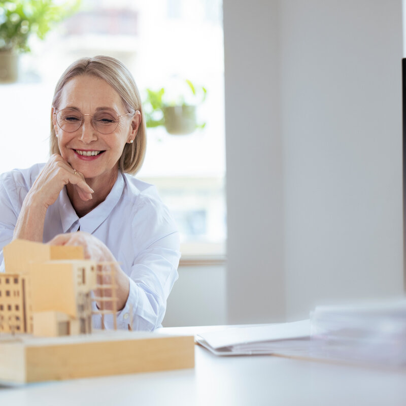 Smiling businesswoman checking model at workplace