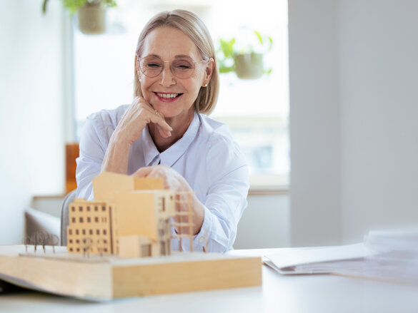 Smiling businesswoman checking model at workplace