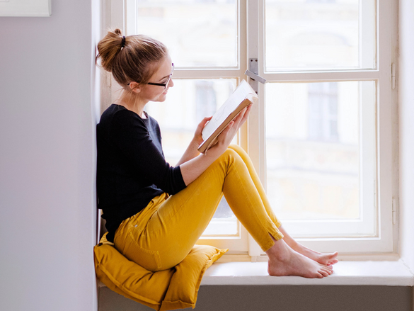 Donna che legge davanti alla finestra