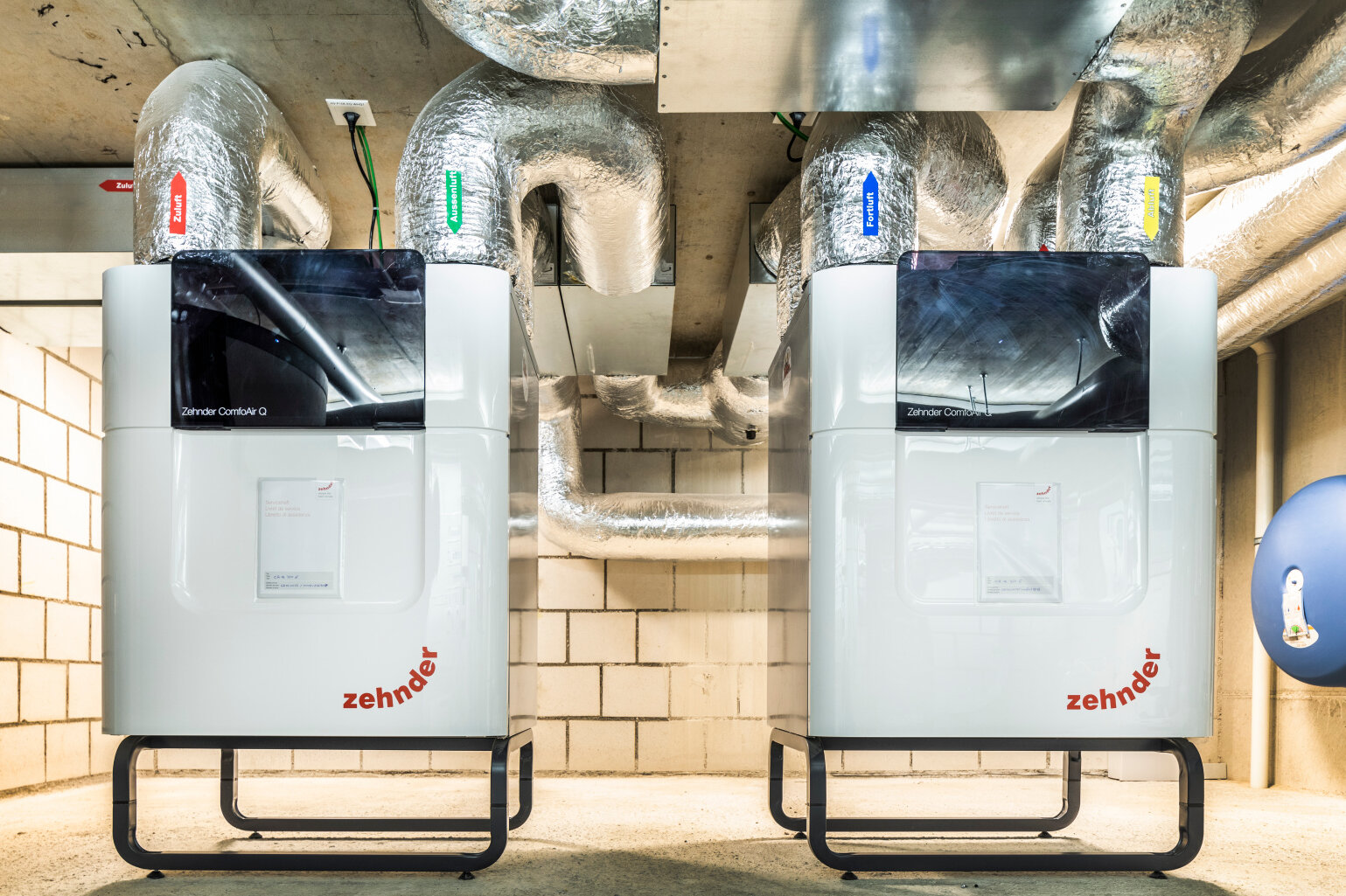 Deux appareils de ventilation dans la cave d’un immeuble collectif